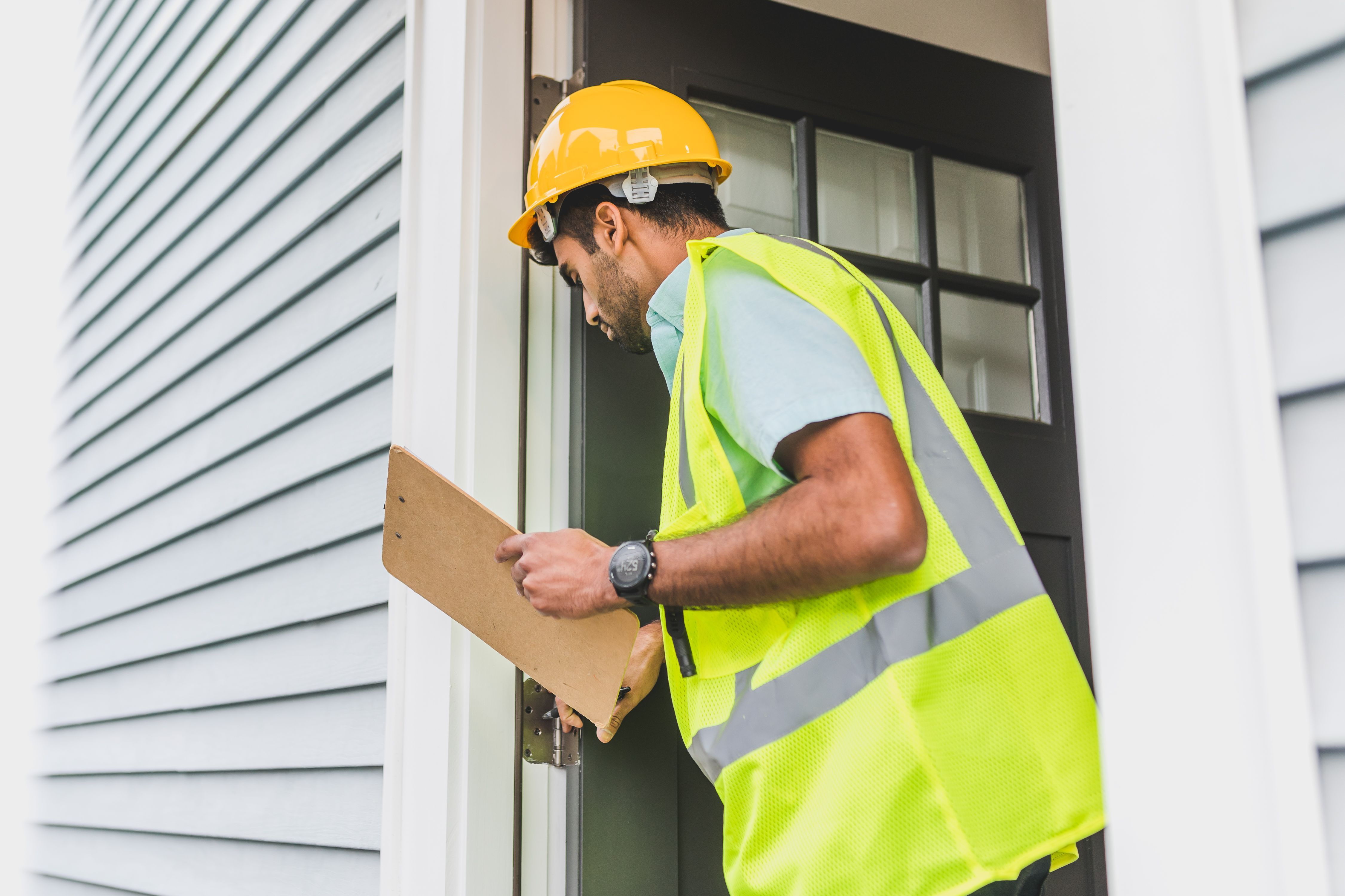 Property inspector taking notes at a house entrance.