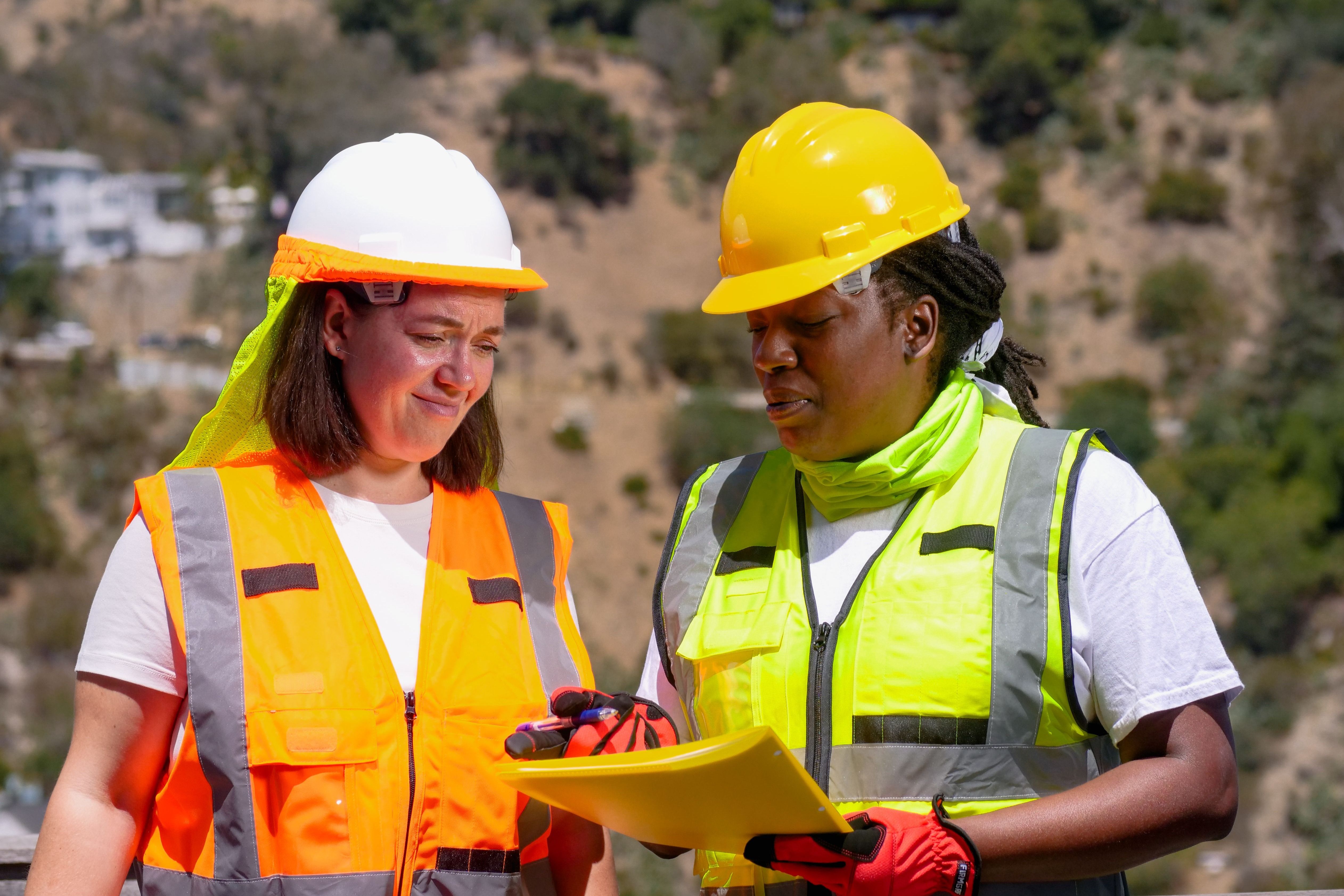 Two field employees reviewing a work document together.